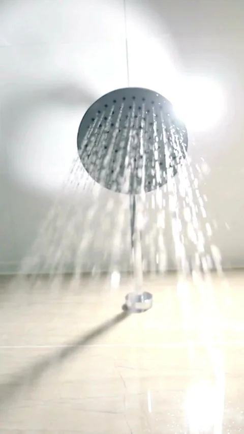 Water spraying from round chrome shower head in bathroom Stock Footage 331934941