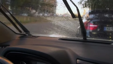 Water spraying on windshield and wipers cleaning glass from inside car view Stock Footage 333649647