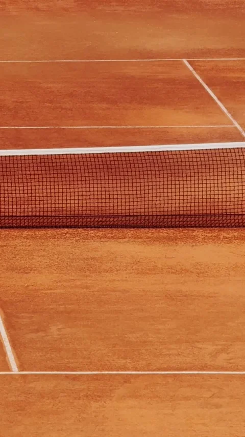 Water sprays across an empty clay tennis court behind the net, showing Stock Footage 337252154
