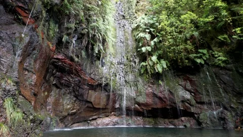Water spring running down the cliffs, rocks with sun shining on it Stock Footage 170838405