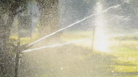 Water springer watering the grass around Stock Footage 33357168