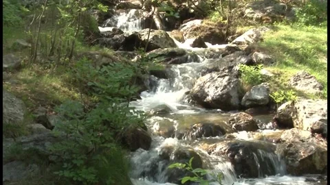 The water of a stream descends among the rocks Stock Footage 140915161