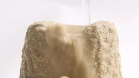 Water Stream Eroding Sandy Granular Mound Dissolving and Collapsing Stock Footage 339620425
