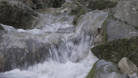 Water stream flowing between rocks, closeup, 4K, DNxHR Video stock 152532200