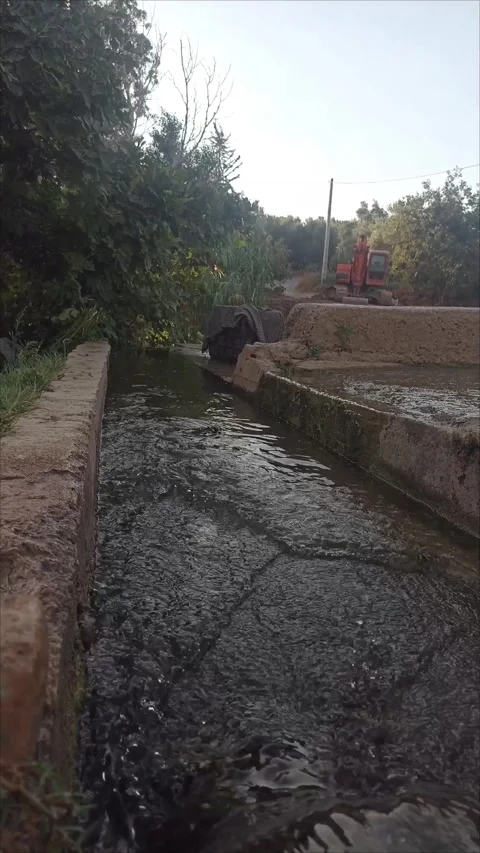 Water stream flowing inside a concrete irrigation canal in farmland 스톡 동영상 339737942