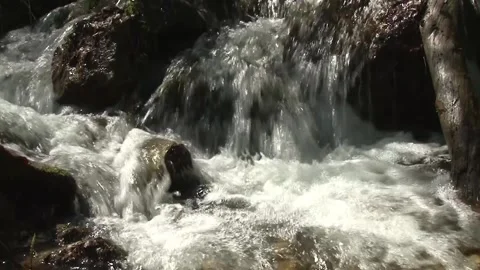 The water of a stream flows restlessly among the rocks Stock Footage 140915186