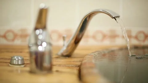 Water stream flows from the water tap into the tub Stock Footage 86176665