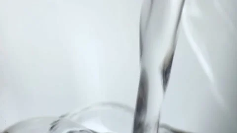 Water stream in slow motion falls on smooth clean surface, creating air bubbles Stock Footage 236503759