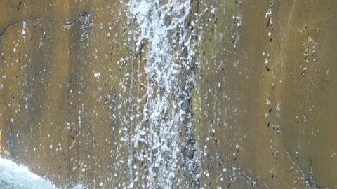 Water streaming down a rocky cliff face, captured in 4K slow motion 120fps Stock Footage 286014575