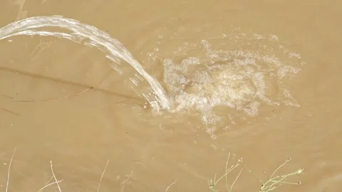 Water streaming into a puddle of brown water Stock Footage 328536648