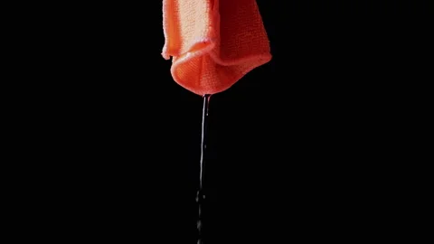 Water Streams Flowing Down Orange Microfiber Cloth On Black Background. Stock-Footage 312013524