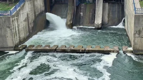 Water with strong pressure flows through  the locks on the dam of the lake. Stock Footage 238133754