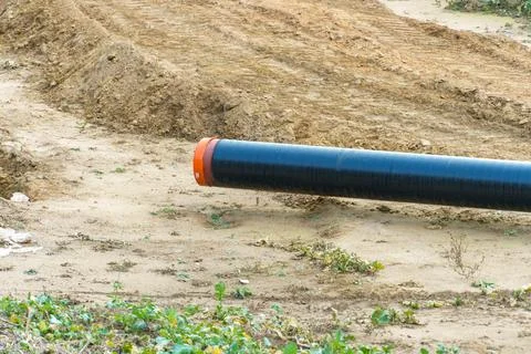A water supply pipe with insulation for supplying hot water. A dug trench f.. Stock Photos