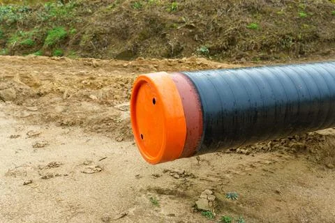 A water supply pipe with insulation for supplying hot water. A dug trench f.. Stock Photos