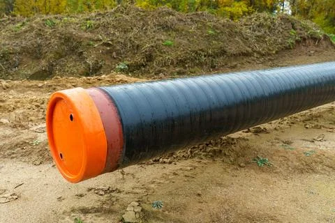 A water supply pipe with insulation for supplying hot water. A dug trench f.. Stock Photos