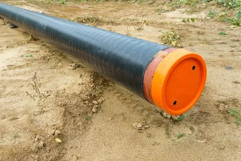 A water supply pipe with insulation for supplying hot water. A dug trench f.. Stock Photos
