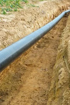 A water supply pipe with insulation for supplying hot water. A dug trench f.. Stock Photos