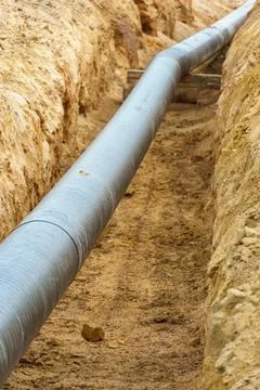 A water supply pipe with insulation for supplying hot water. A dug trench f.. Stock Photos