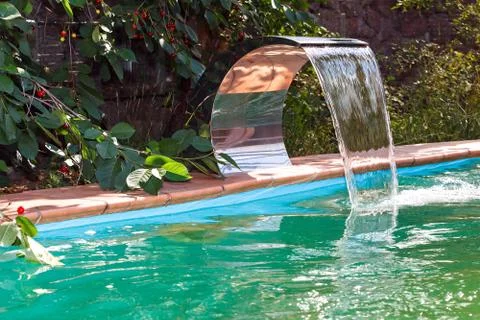 Water supply to the pool by a waterfall. Recirculation and cleaning system. Stock Photos