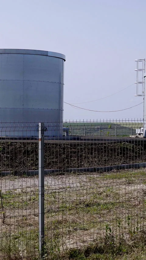 Water supply system featuring large cylindrical storage tanks surrounded by a Stock Footage 313926715