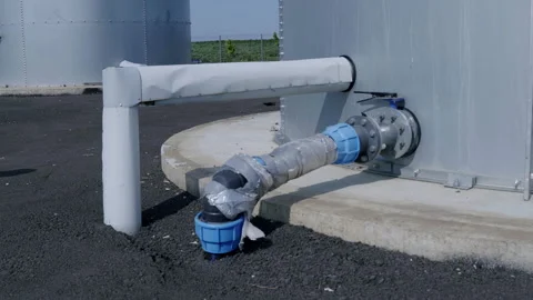 Water supply system infrastructure featuring a large pipe connected to a storage Stock Footage 312739214