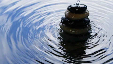 Water surface with balanced stacked rocks and clouds in sky reflection Stock Footage 139868810