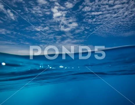 Water surface in blue sea splitted with sky and air by waterline Stock Photos