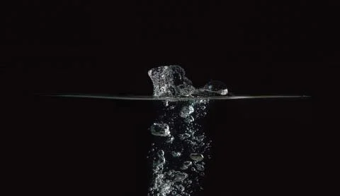Water surface with bubbles isolated on black background. Drop of water fallen Stock Photos