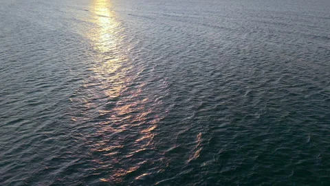 Water surface with golden reflections on beach background Video stock 318117088