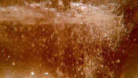 Water Surface in a Light Orange Light Boiling With Plurality of Bubbles Stock Footage 76389472