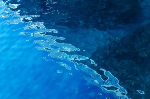 Water surface making multiple water circles against blue background beauty Stock Photos