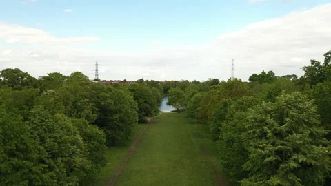 Water surface in park, high voltage power lines and urban neighbourhood Stock-Footage 159156624