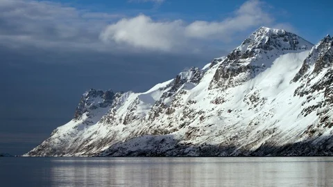 Water surface reflecting high altitude mountains with cloudy sky background Stock Footage 121573380