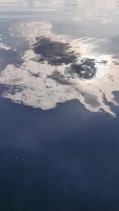 Water surface reflecting sun and clouds. vertical. 库存影片 335390683