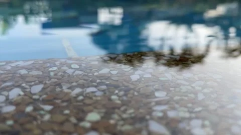 Water surface reflecting tree shadows next to a stone Stock Footage 312096813