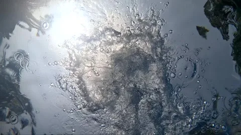 Water surface reflections capture sunlight and debris in four frames Stock Footage 325620451