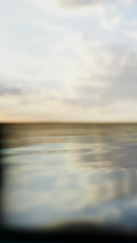 Water surface reflects clouds and sky during a calm afternoon Stock Footage 335689126
