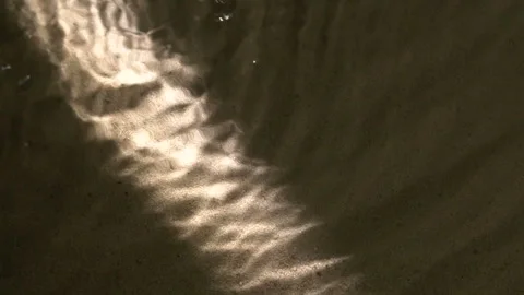 Water surface ripples and splashes, bright light and shadow on dark sand texture Vídeos de archivo 278256466