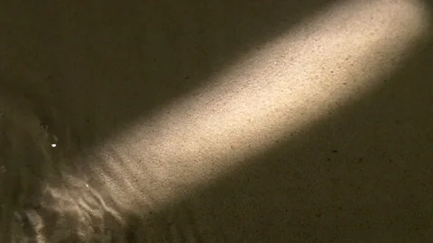 Water surface ripples and splashes, bright light and shadow on dark sand texture Stock Footage 284414149