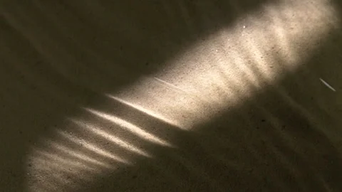 Water surface ripples and splashes, bright light and shadow on dark sand texture Stockbeeldmateriaal 285822805