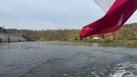 Water surface ripples, boat navigates along a calm river, passing concrete dam Stock Footage 332834716