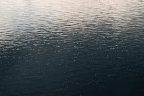 Water surface with splashes from falling rain Stock Photos