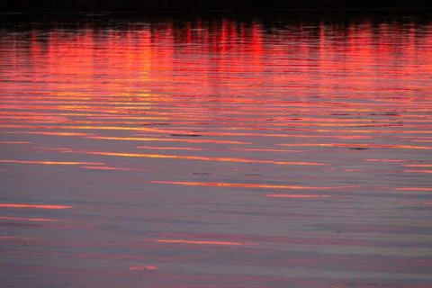 Water surface with sunset orange light Stock Photos