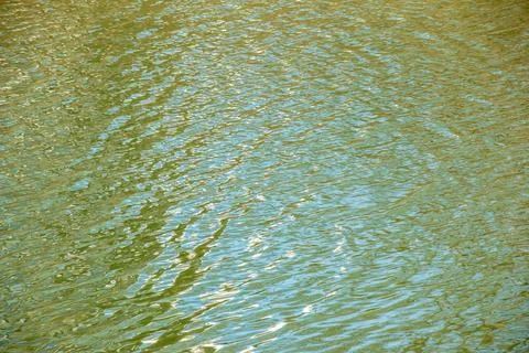 Water surface in sunset rays, river ripples or ocean with small waves, calm.. Stock Photos