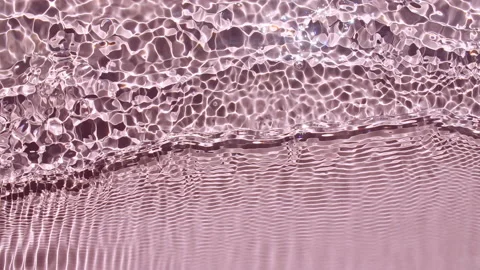 Water surface texture top view. Water splash pink colored. Pure blue water with Stock Footage 168183812