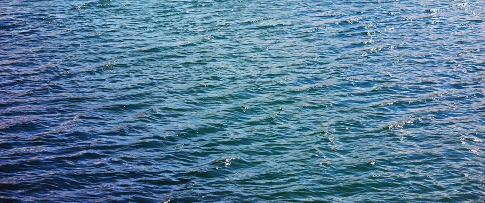 Water surface. The texture of the water. Waves on the lake in windy weather. Stock Photos
