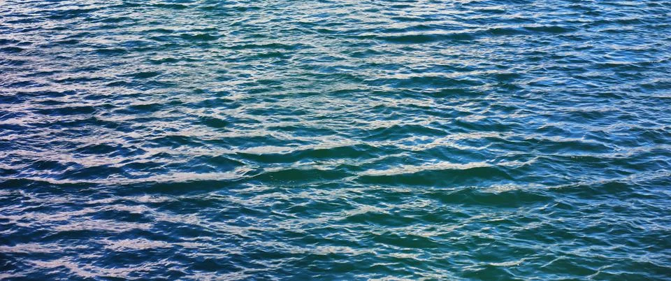 Water surface. The texture of the water. Waves on the lake in windy weather. Stock Photos