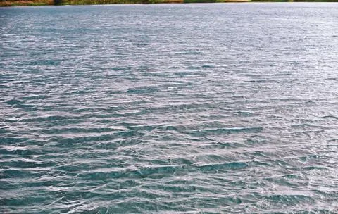 Water surface. The texture of the water. Waves on the lake in windy weather. Stock Photos