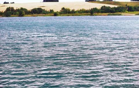 Water surface. The texture of the water. Waves on the lake in windy weather. Stock Photos