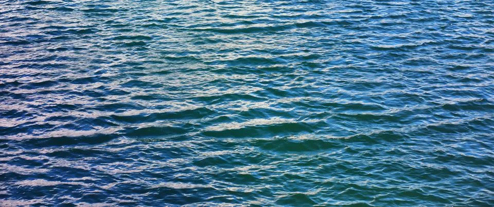 Water surface. The texture of the water. Waves on the lake in windy weather. Stock Photos